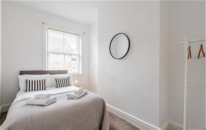 ein weißes Schlafzimmer mit einem Bett mit zwei Handtüchern darauf in der Unterkunft Perfectly Located 4 Storey Townhouse With 2 Parking Spaces In Central Harrogate in Harrogate