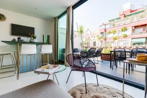 uma sala de estar com uma varanda com cadeiras e uma televisão em En Ville Boutique Apartments Sant Antoni em Barcelona