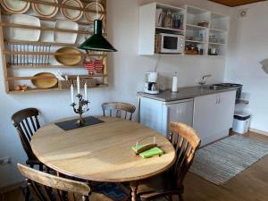 a kitchen with a wooden table and chairs in a room at Bredgade 10 Thyborøn in Thyborøn