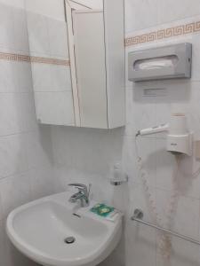 bagno bianco con lavandino e specchio di Hotel Colibrì a Finale Ligure