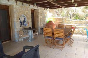 a man sitting at a table on a patio at Perimenis Seaside House in Gerolimenas