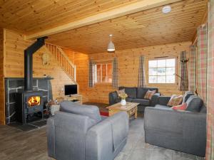 a living room with couches and a fireplace at Allt Lodge in Inverness
