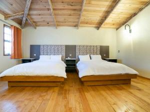 2 letti in una camera con soffitti in legno e pavimenti in parquet di Collection O Casona De Minas a Mineral del Monte
