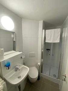 a bathroom with a shower and a toilet and a sink at Hotel Sophia in Warendorf