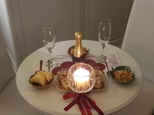 a white table with a candle and wine glasses at Sweet Dreams in La Spezia