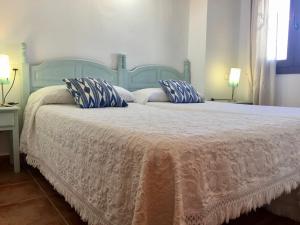a bedroom with a bed with a blue headboard and pillows at Apartamentos Turisticos Trajano in Bolonia