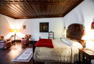 ein Schlafzimmer mit einem großen Bett und einer Holzdecke in der Unterkunft Quinta Da Agra in Ponte de Lima