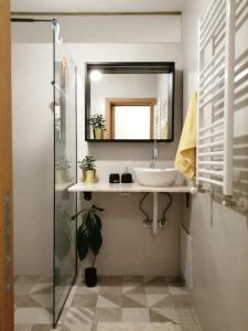 uma casa de banho com um lavatório e um espelho em Super Central & Panoramic Nick's Apartment em Pristina