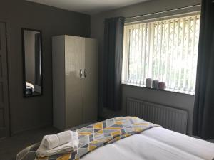 a bedroom with a bed and a dresser and a window at Hygge House in Middlesbrough