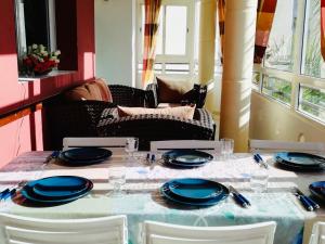 una mesa con platos azules y servilletas. en La Siesta Bel appartement bord de mer avec piscine en Mohammedia