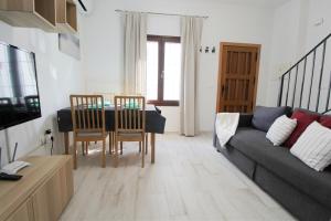 salon z kanapą, stołem i krzesłami w obiekcie Casa Puerta de la Alcazaba Antequera w mieście Antequera