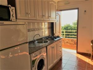 a kitchen with a washing machine and a sink at Apartamentos Turisticos Trajano in Bolonia