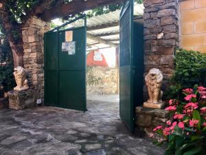 a green door with two statues in a courtyard at Apartamentos Turisticos Trajano in Bolonia