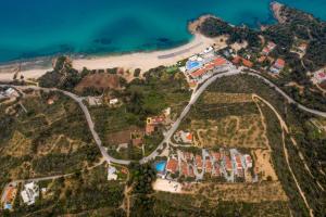 eine Luftansicht auf einen Strand mit Häusern und einer Straße in der Unterkunft Zoe Hotel, Trypiti Beach Resort & Hive water park in Limenaria