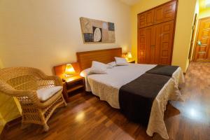 ein Hotelzimmer mit einem Bett und einem Stuhl in der Unterkunft Hotel de Montaña Rubielos in Rubielos de Mora