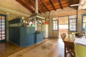 a large kitchen with a stove and a table at Mandala Maresias in Maresias