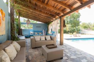 a living room with couches and a swimming pool at Mandala Maresias in Maresias