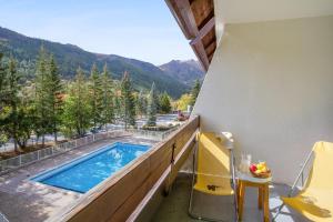 a balcony with a swimming pool and a table and chairs at Pierre et Vacances Serre Chevalier Chantemerle in Saint-Chaffrey +18 photos