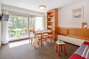 a room with a table and chairs and a window at Pierre et Vacances Serre Chevalier Chantemerle in Saint-Chaffrey