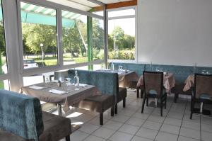 a dining room with tables and chairs and windows at Henri 4 in Rostrenen