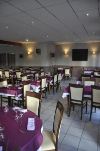 a dining room with purple tables and chairs and a tv at Henri 4 in Rostrenen