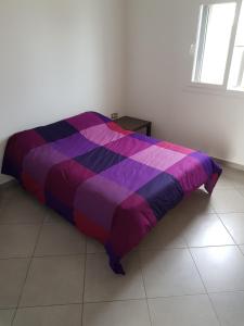 a bed with a colorful comforter in a room at appartement charmante à Cabo negro in Martil +21 photos