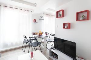 a living room with a table and chairs and a television at Chez Fred&Vir Arras in Arras