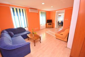 SeaSide House في هرسك نوفي: غرفة معيشة مع أريكة زرقاء وكرسي