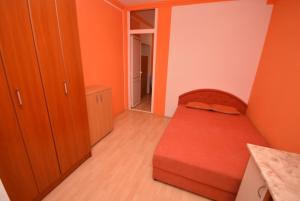 ein kleines Schlafzimmer mit orangefarbenen Wänden und einem Bett in der Unterkunft SeaSide House in Herceg-Novi