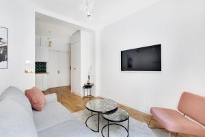 een witte woonkamer met een bank en een tafel bij Pick A Flat's Apartment in Parc Monceau - Rue de Naples in Parijs