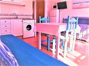 a kitchen with a table and chairs and a washing machine at Apartamentos Turisticos Trajano in Bolonia
