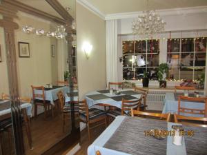 Altstadt Hotel Rheinblick في دوسلدورف: غرفة طعام بها طاولات وكراسي وثريا
