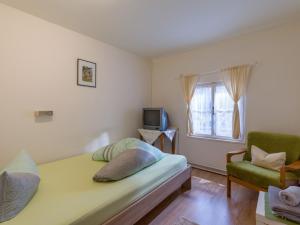 a bedroom with a bed and a chair and a television at Landgasthof Oberlander in Kirchbichl