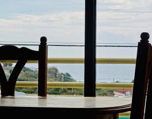una mesa y una silla con vistas al océano en Apartamentos Turisticos Trajano, en Bolonia