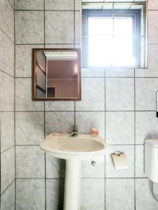 uma casa de banho com um lavatório e um espelho em Hotel Tiquatira - Zona Leste em São Paulo