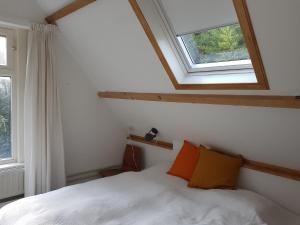 1 dormitorio con cama blanca y ventana en huisje Nieuw Vliet, en Nieuwvliet