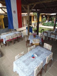 a group of tables and chairs with a flag at Pousada Paraguaya in Angra dos Reis