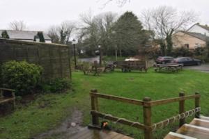 un parco con panchine e tavoli da picnic sull'erba di The Dolphin Inn a Kingsbridge