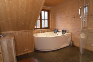 a large tub in a wooden bathroom with a window at Houten villa Albert in Den Ham +13 photos
