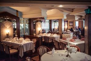 a restaurant with white tables and chairs and people in the background at Hotel Bacchus in Livno