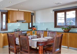 a kitchen with a wooden table with chairs and a tableablish at Vasia Villas in Milatos