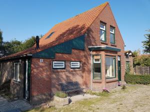 尼維萊特的住宿－huisje Nieuw Vliet，砖房,前面有长凳
