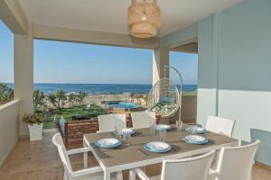 comedor con mesa y vistas al océano en Aptenia Villa, en Dhrámia