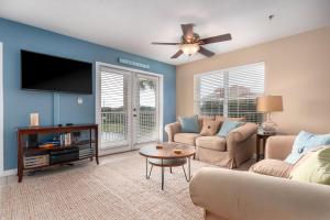 a living room with a couch and a flat screen tv at Gulf Place Caribbean in Santa Rosa Beach