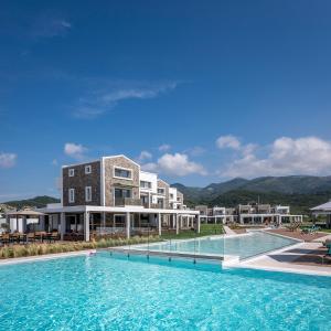 una grande piscina di fronte a un edificio di Thalassa Suites ad Almiros Beach