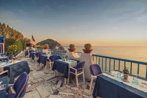 een restaurant met tafels en stoelen aan de oceaan bij Hotel Villa Maria in Ischia