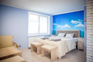 a bedroom with a large bed with a blue wall at Sloneczna 10tka in Sztutowo