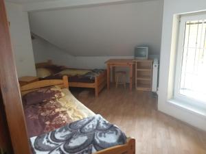 1 dormitorio con 2 camas, escritorio y ventana en Połonina en Korbielów