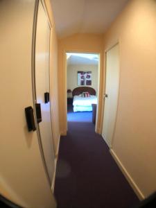 a hallway of a hotel room with a mirror at Auv'hôtel in Mauriac