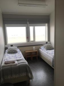 um quarto com 2 camas e uma janela em Guesthouse Reynir em Reynir